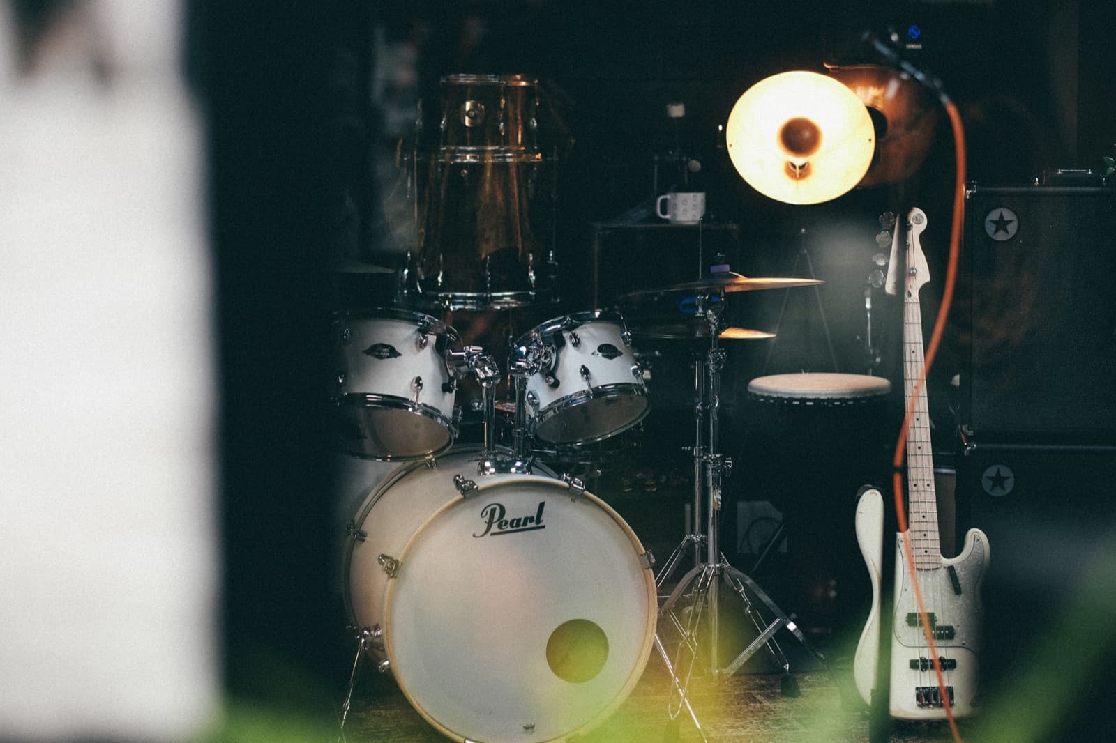 The Audio Playground rehearsal room, lit warmly with Pearl drum kit and bass guitar
